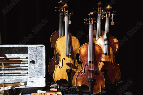 Range of violins and fiddles on a table.
