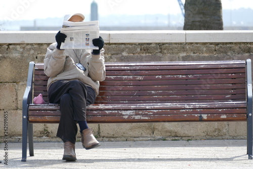 Canvastavla Anziano signore seduto sulla panchina mentre legge un giornale
