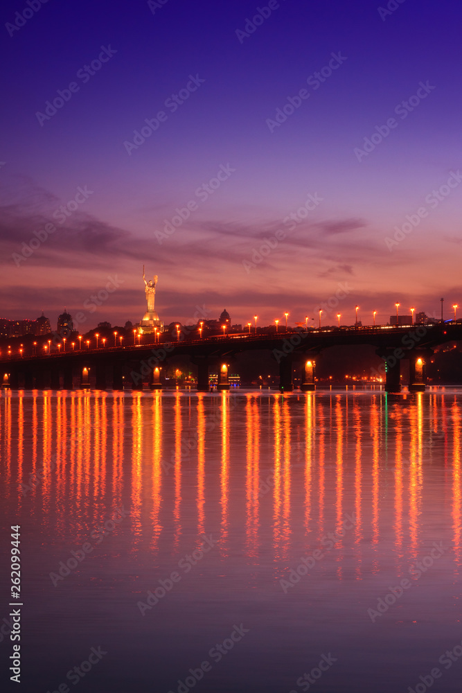 Panoramic view of the Paton bridge, Motherland monument and Dnieper river at night, beautiful cityscape with city lights, Kiev the capital of Ukraine, vertical image