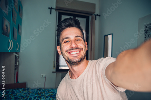 Obraz na plátně Handsome caucasian man taking a self portrait indoor at home