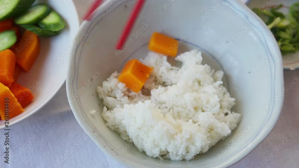 Preparation of a rice bowl with roast duck, butternut squash and cucumber Preparation of a rice bowl with roast duck, butternut squash and cucumber