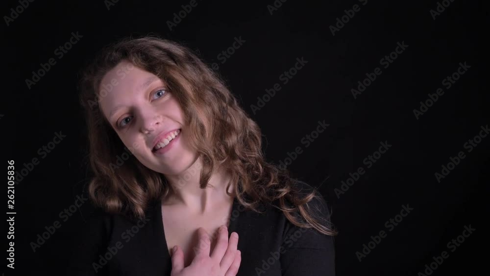 Portrait of young curly-haired girl shows suprise and gladness into camera on black background. Portrait of young curly-haired girl shows suprise and gladness into camera on black background.