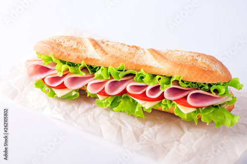 Ham sandwich on a paper bag on white