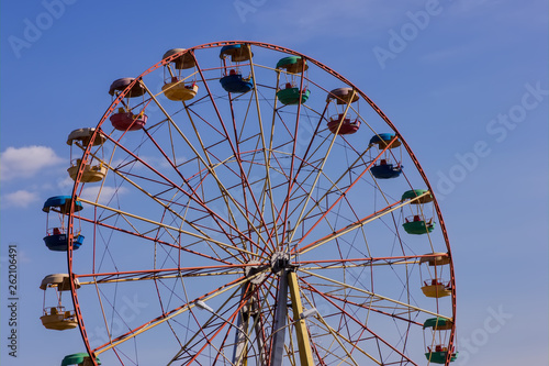 Ferris wheel in the park against blue sky.