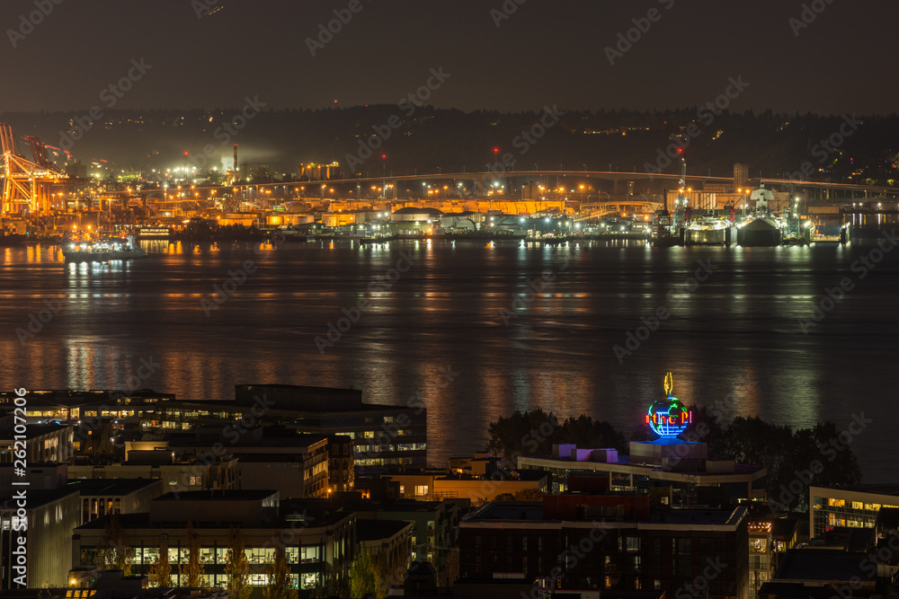 Orange lights iluminate the port of Seattle and Elliott Bay at night.