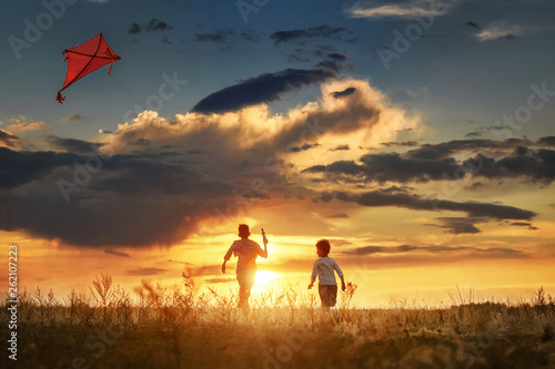 Children with a kite at sunset