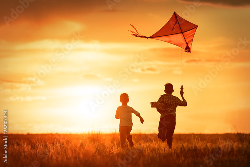 Children with a kite at sunset photo
