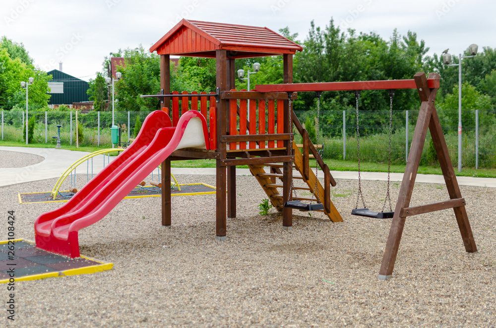Outdoor playground with a slide and wooden swings Outdoor playground with a slide and wooden swings