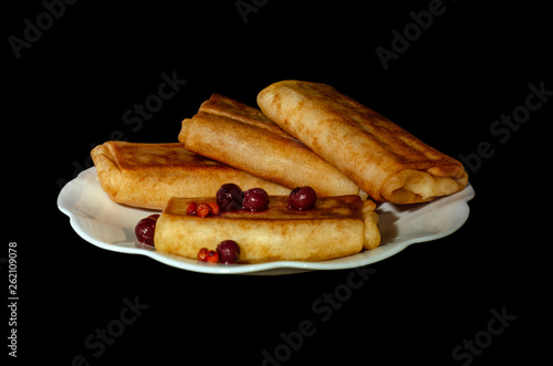 fried pancakes. stuffed pancakes. wrapped pancakes on a white plate with berries