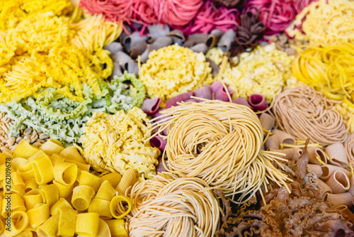Many types of uncooked Italian pasta of various colors and shapes