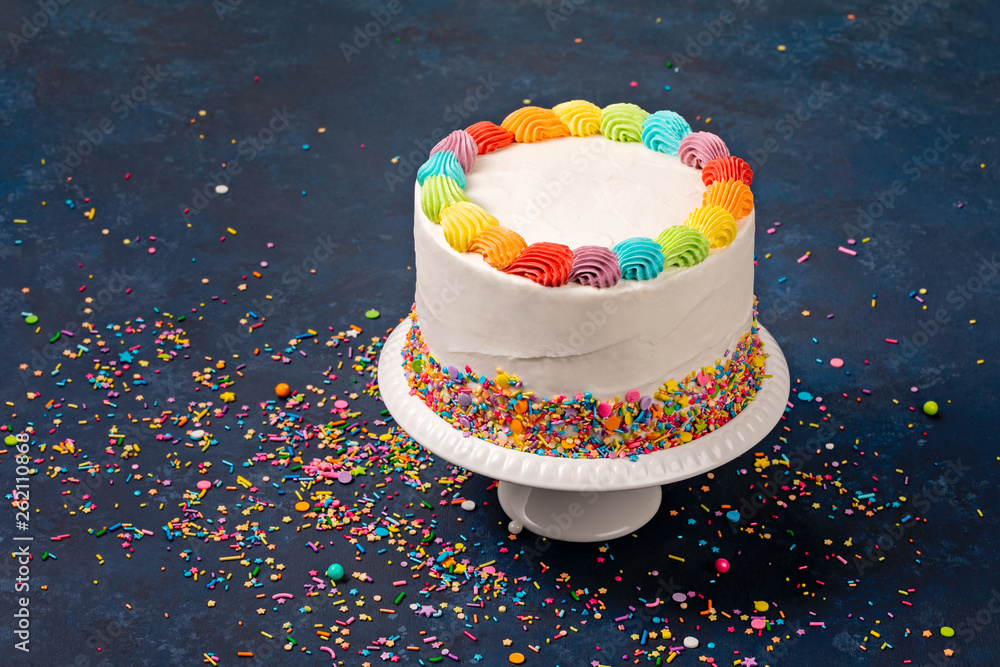 White Birthday cake with rainbow icing and colorful Sprinkles over a ...