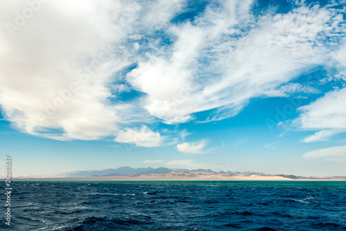 Seascape  view of the blue sea with high bald mountains in the background