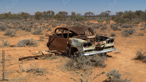 Rusty wreck of crashed car in the middle of desert  warning to inattentive drivers   Stuart Highway  Australia