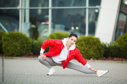 Fitness girl. Young sports woman stretching in the modern city. Healthy lifestyle in the big city photo