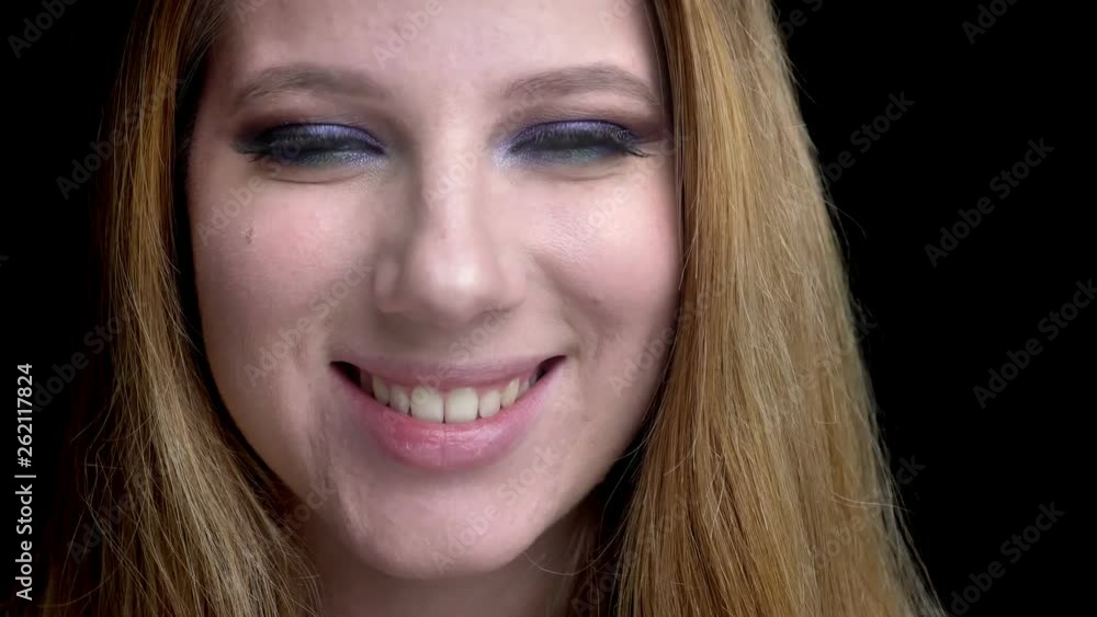 Closeup shoot of young beautiful female face smiling happily with stunning makeup with background isolated on black Closeup shoot of young beautiful female face smiling happily with stunning makeup with background isolated on black