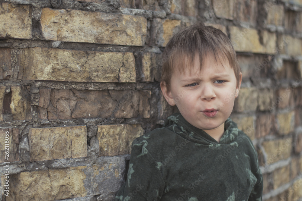 Child confused, depressed, upset. Little boy near the brick destroyed wall. Child confused, depressed, upset. Little boy near the brick destroyed wall.
