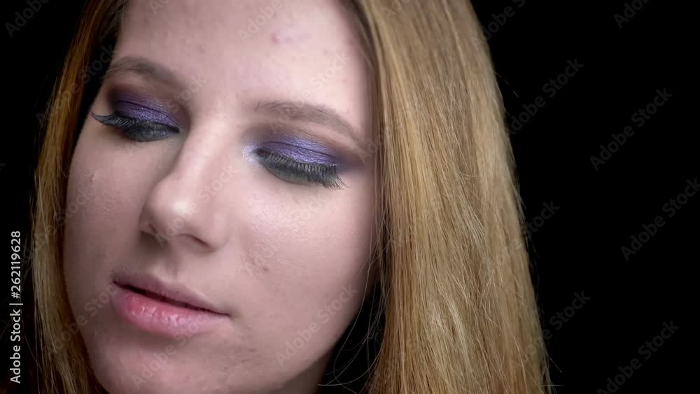 Closeup shoot of young beautiful female face with stunning makeup looking at camera with cutesmile with background isolated on black Closeup shoot of young beautiful female face with stunning makeup looking at camera with cutesmile with background isolated on black