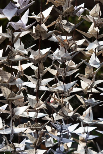 Background texture of folded origami paper cranes made from vintage papers, vertical aspect