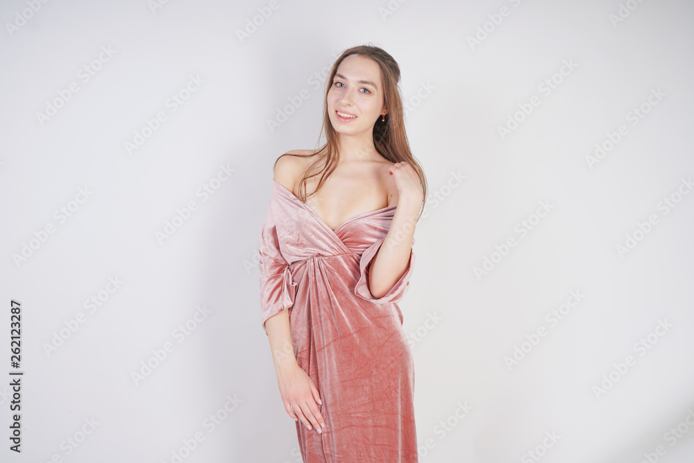 cute young caucasian teenager girl in pink velvet dress stands and smiles on white background in Studio cute young caucasian teenager girl in pink velvet dress stands and smiles on white background in Studio