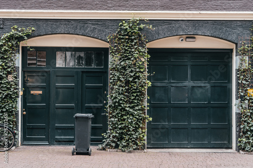 Traditional european garage with black brick and dark gates