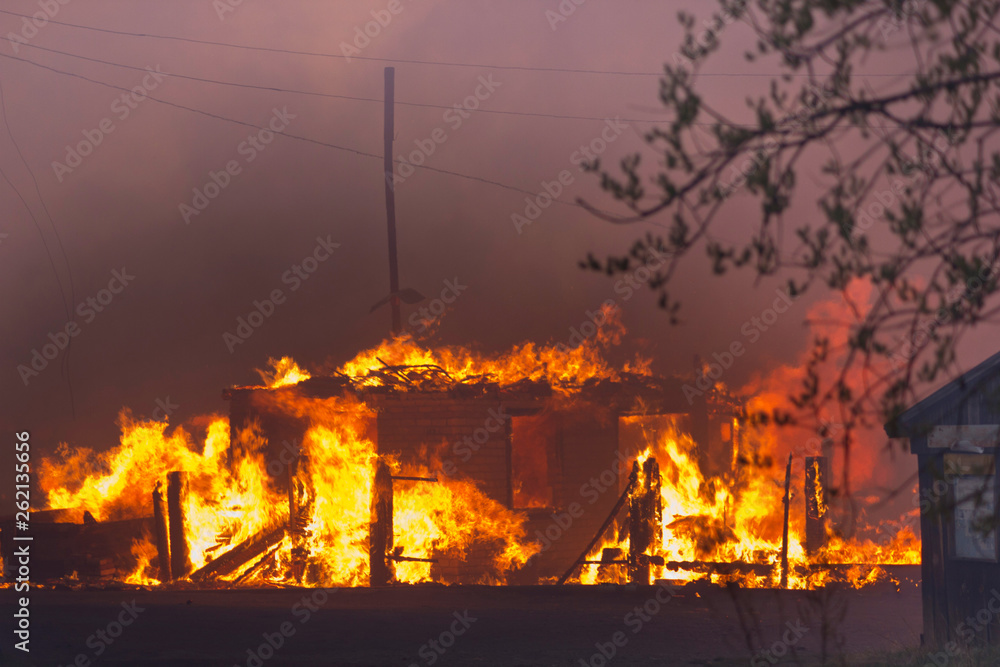 The building is on fire. The house is burned in the fire in the evening. Flames destroy the building at night.