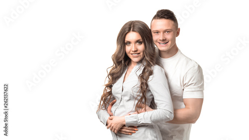 Married couple. Man holding woman and looking at camera. Pregnacy, couple goal, happiness, feature, dream and female health concept. photo