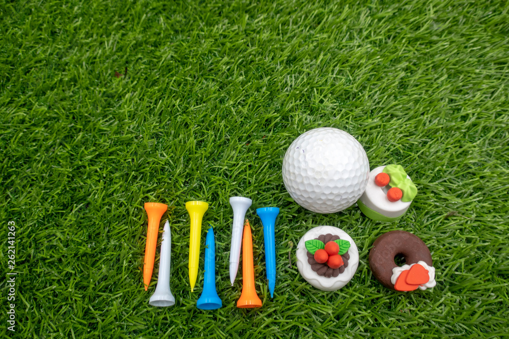 Naklejka premium Multicolour tees are on green grass for golfer 's birthday with cakes