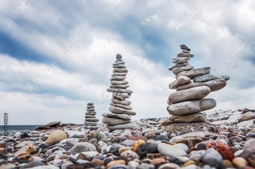 Towers of balanced dolomite stones on the beach on a cloudy day
