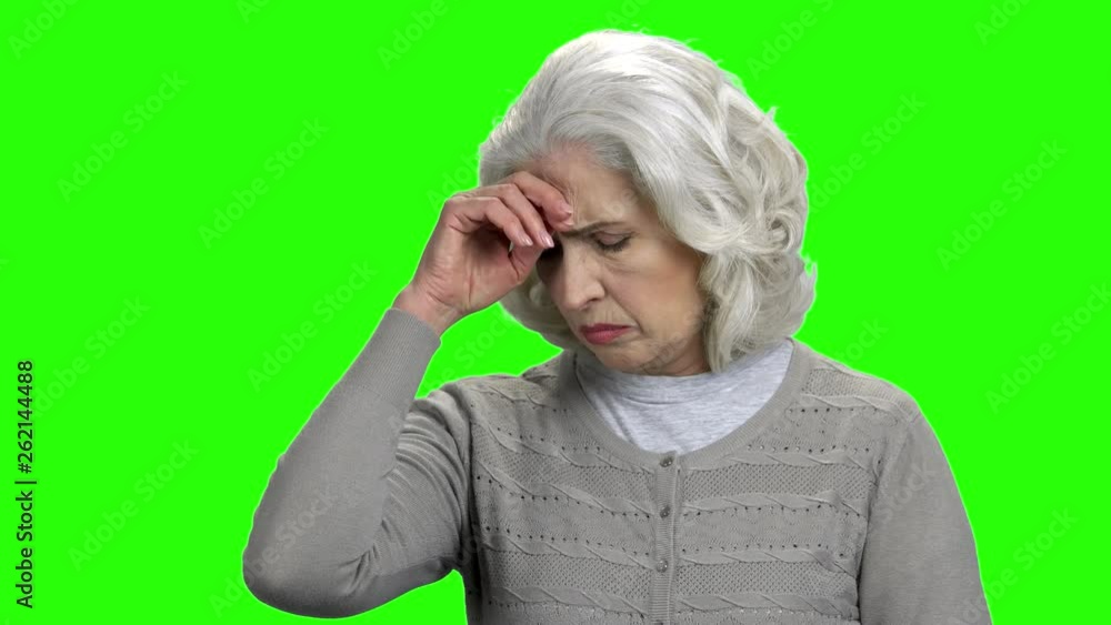 Portrait of upset elderly woman on green screen. Aged worried woman with pensive expression touching her head. Alpha Channel background. Portrait of upset elderly woman on green screen. Aged worried woman with pensive expression touching her head. Alpha Channel background.