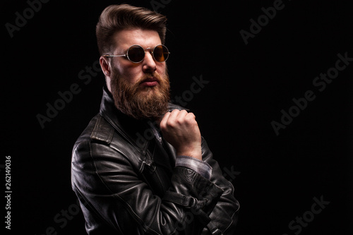 Attractive bearded man with styish glasses over black background