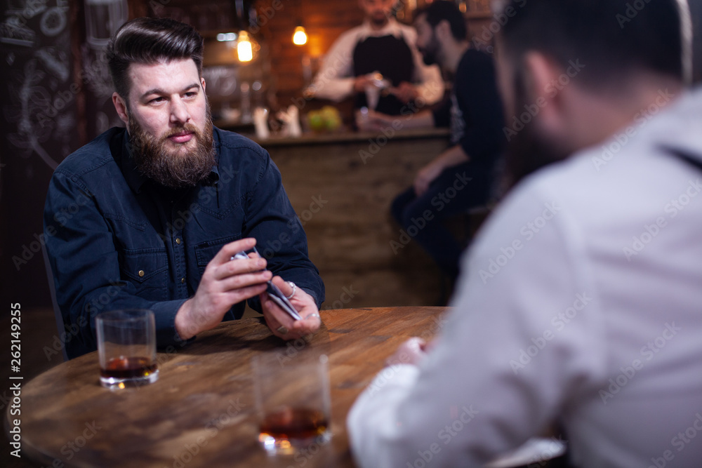 Attractive bearded men drinking whiskey in a pub