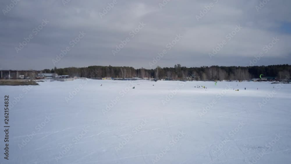 Sea in winter in Siberia. Snow and ice on the sea to the shore in the distance with kiters Sea in winter in Siberia. Snow and ice on the sea to the shore in the distance with kiters
