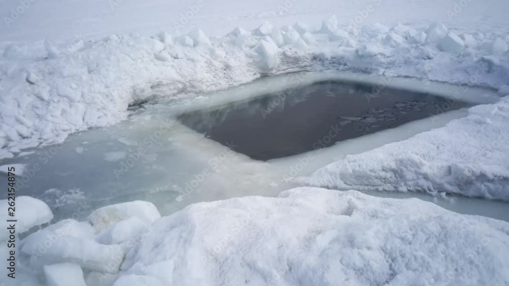 Large ice hole for swimming in thick ice on a winter day Large ice hole for swimming in thick ice on a winter day