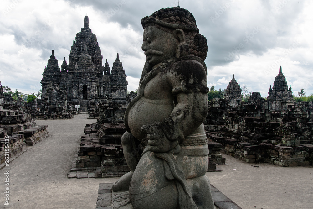 A view of Candi Sewu (Sewu Temple) with a dvarapala (guard) at the front A view of Candi Sewu (Sewu Temple) with a dvarapala (guard) at the front