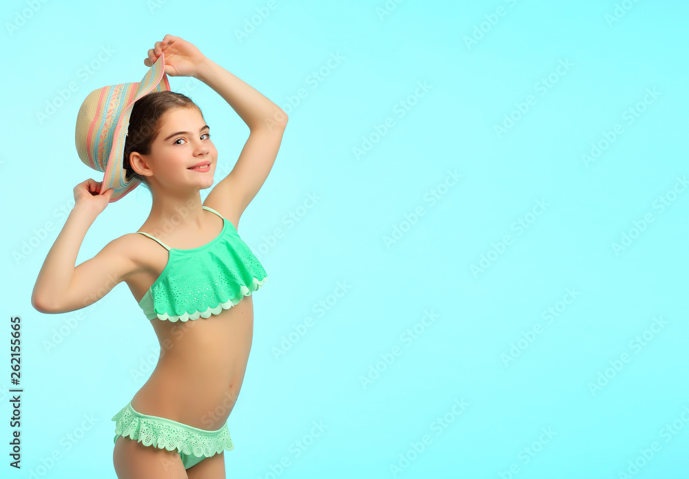 Bright summer portrait of 10-year-old girl in swimsuit and hat on blue  background Stock 写真 | Adobe Stock