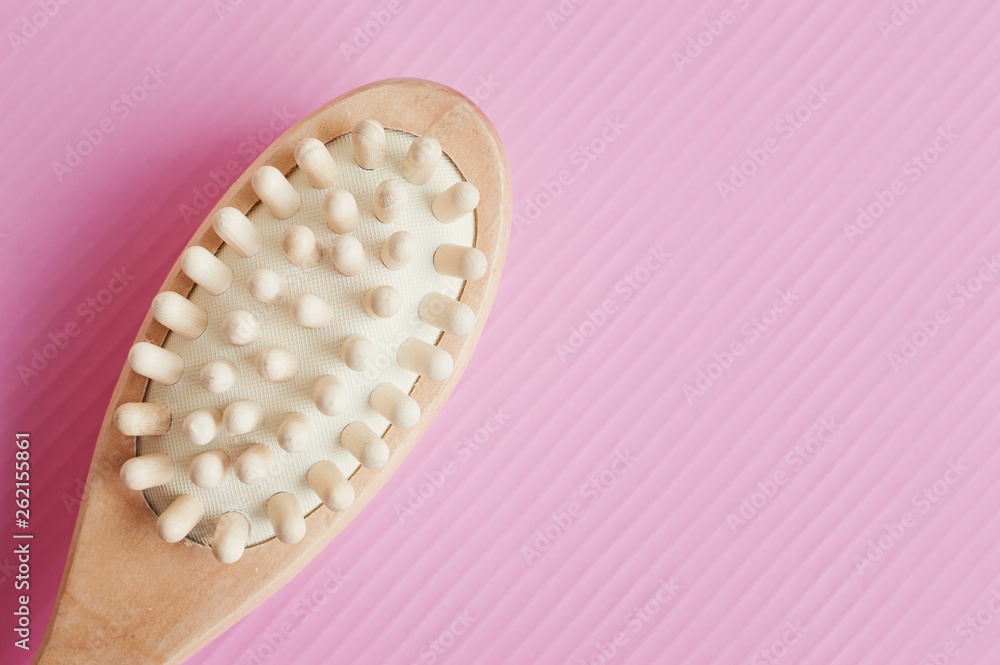 Brush for anticellulite body massage on pink background, top view. Body care and spa treatment concept Brush for anticellulite body massage on pink background, top view. Body care and spa treatment concept