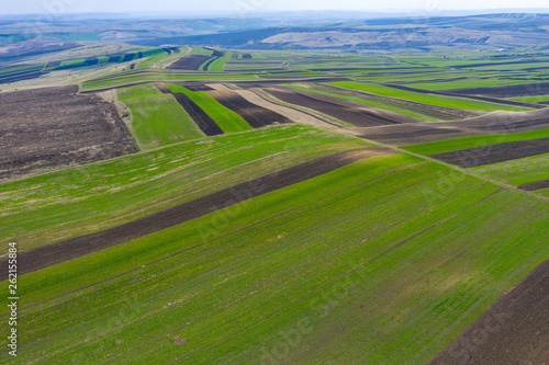 Aerial drone view of agricultural fields of plowed crops