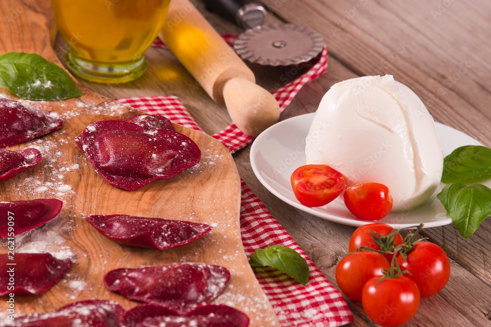 Red heart ravioli with tomato, mozzarella and basil.