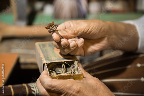 Obraz na plátně adult master restores old musical instruments