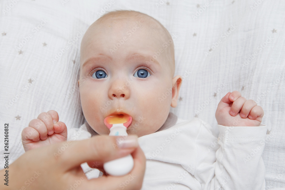 Beautiful Lovely five-month baby girl eating with a spoon. Healthy food. Maternal care. Childcare. Close-up. Beautiful Lovely five-month baby girl eating with a spoon. Healthy food. Maternal care. Childcare. Close-up.