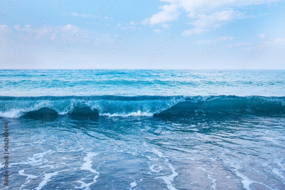 Beautiful view of splashing blue waves near the beach.