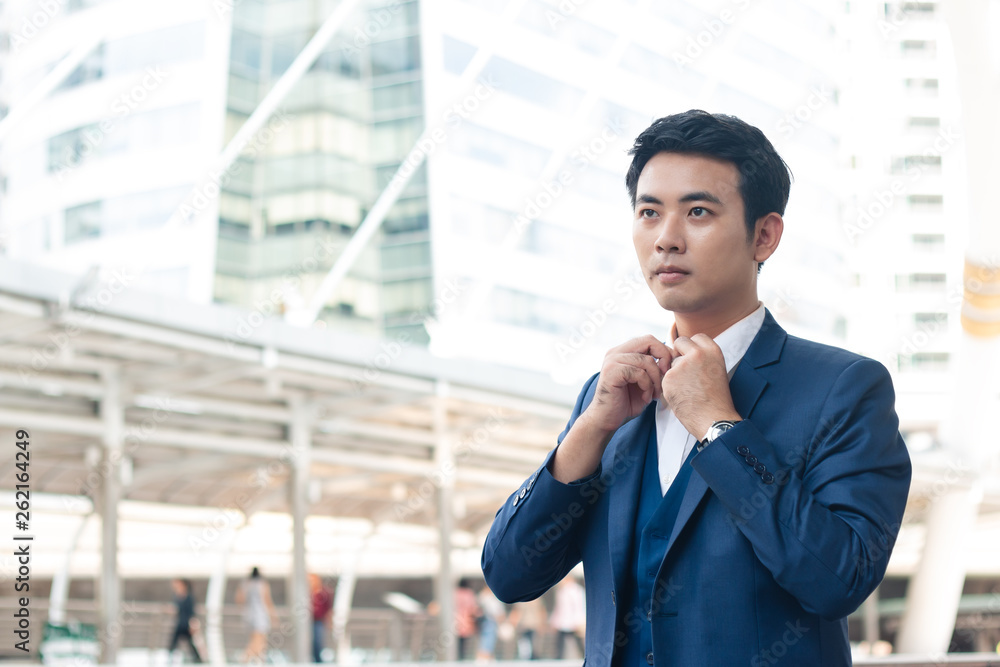 Young businessman in blue suit adjusting his shirt and thinking smart idea. Young businessman in blue suit adjusting his shirt and thinking smart idea.
