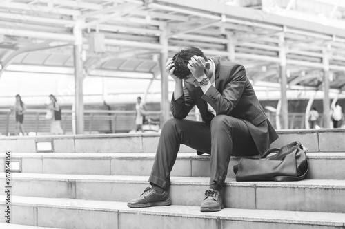 Sad yound and handsome businessman sit on the stair and have bad feeling.black and white © pumpkinjoker