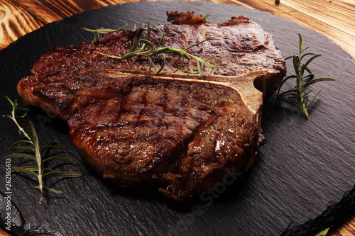 Grilled T-bone steak on stone cutting board. photo