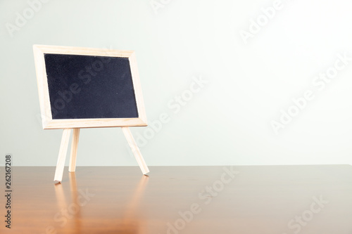 Blackboard with easel stand on wooden table. Empty board. With copy space. concept of education.