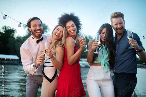 Group of happy friends drinking champagne and celebrating New Year