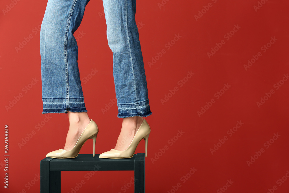 Naklejka premium Young woman in stylish high heels on color background