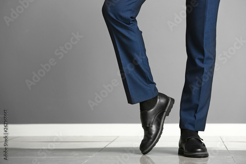 Young man in elegant shoes near color wall photo