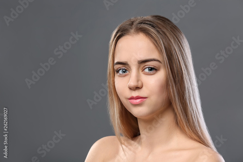 Beautiful young woman with laminated eyelashes on grey background