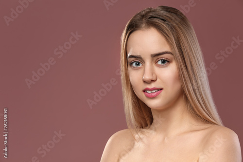 Beautiful young woman with laminated eyelashes on color background